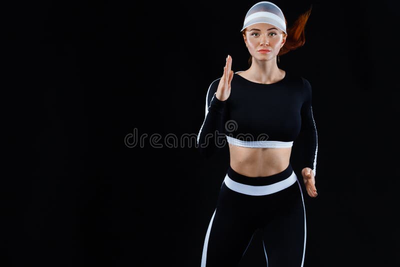 坚强的运动妇女短跑选手,跑在佩带在运动服的黑背景 健身和体育刺激 运行 库存图片 坚强的运动妇女短跑选手,跑在佩带在运动服的黑背景 健身和体育刺激 运行 库存图片